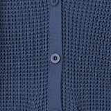 Close-up of a textured knit cardigan in a muted slate blue color, featuring a buttoned front closure and ribbed trim.