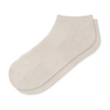 A pair of low-cut ankle socks in a light cream or off-white color, displayed against a solid white background.