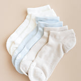 Set of white and light blue ankle socks on a beige background
