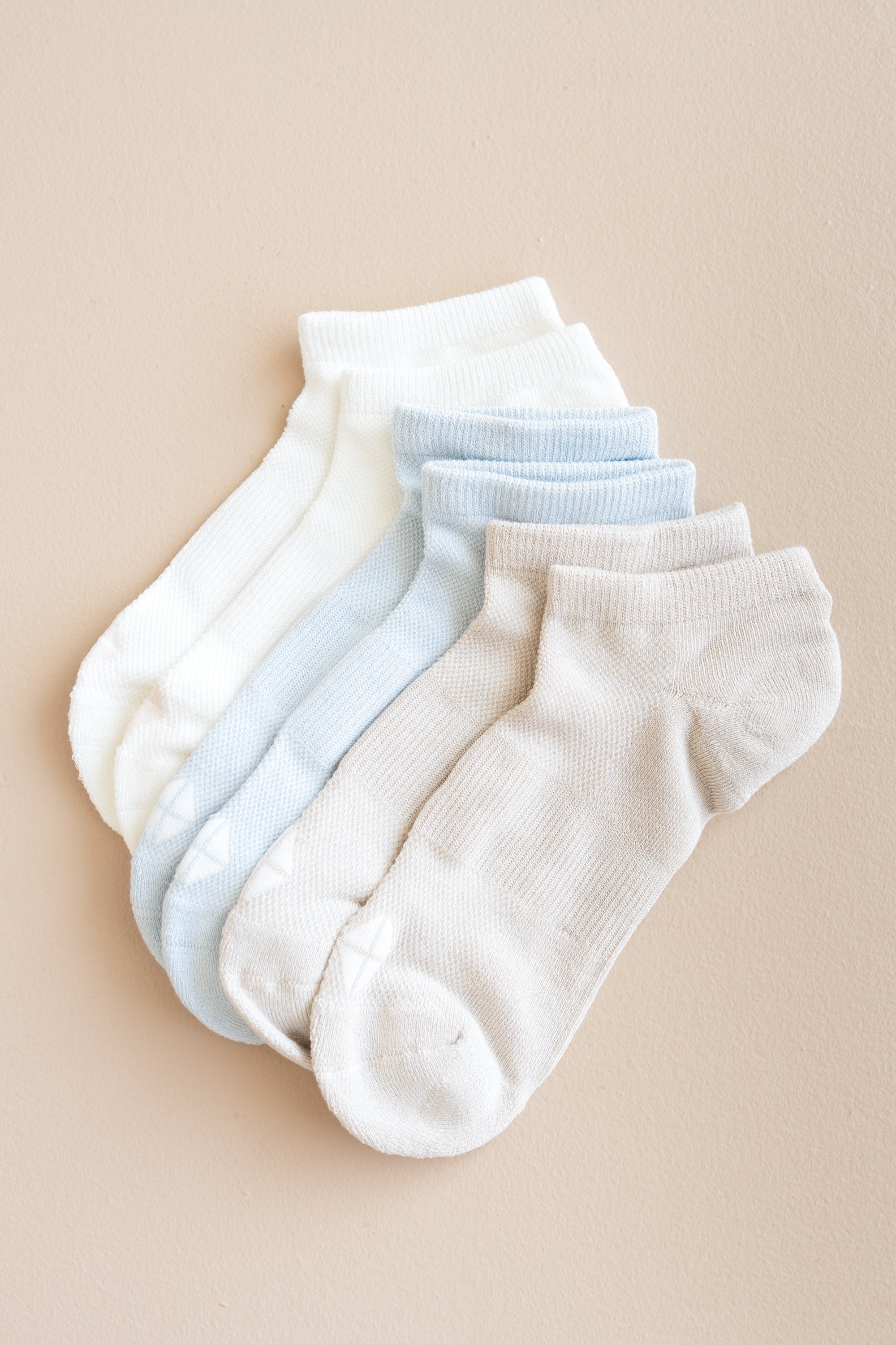 Set of white and light blue ankle socks on a beige background