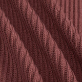 Close-up of a ribbed knit fabric in a dusty rose or mauve-brown color, showing the detailed texture and folds of the yarn.