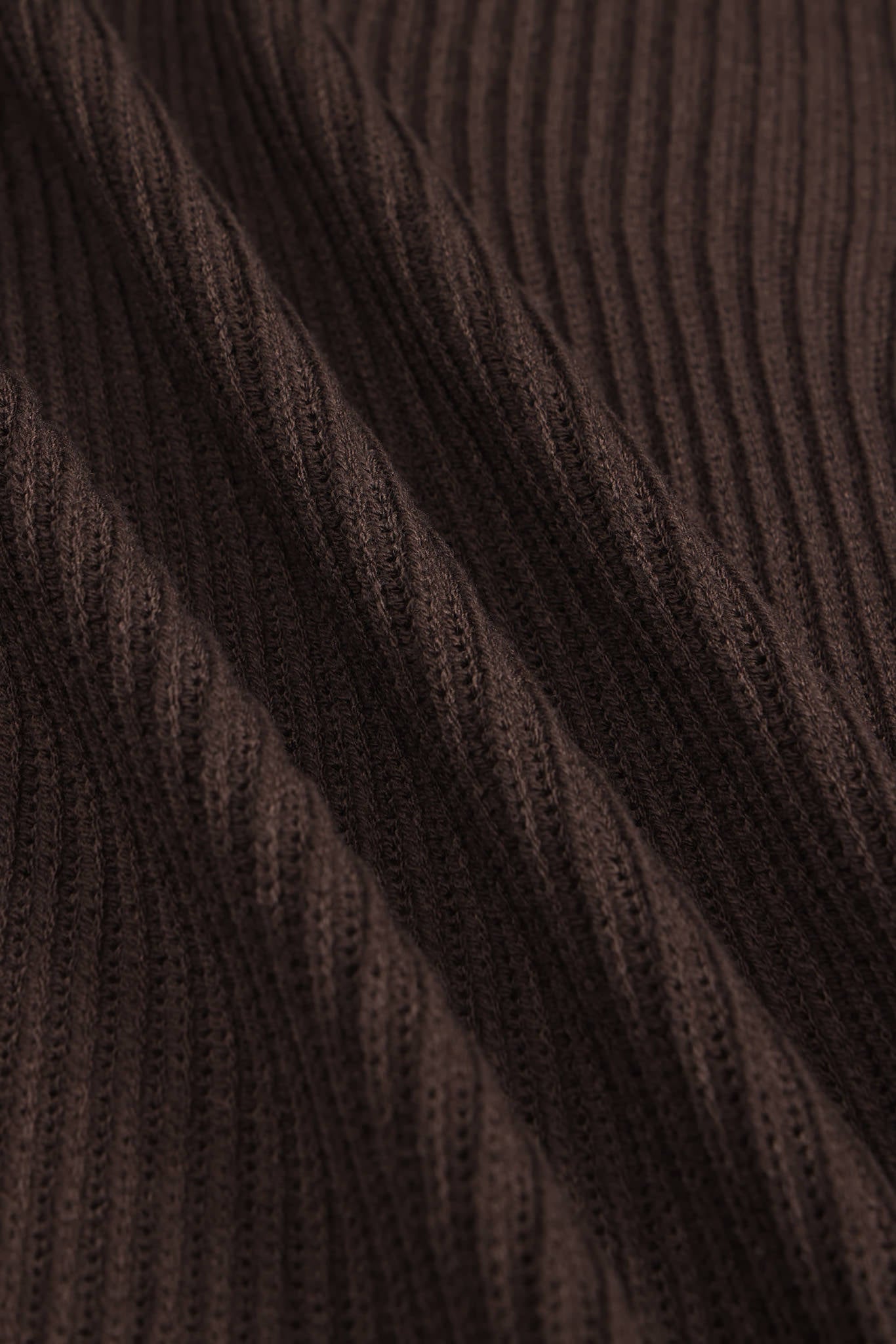 Close-up of dark brown ribbed knit fabric with a textured vertical stripe pattern.