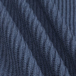 Close-up of a dark blue ribbed knit fabric with diagonal folds showing the detailed knit texture.