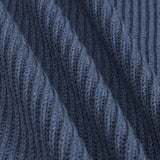 Close-up of a dark blue ribbed knit fabric with diagonal folds showing the detailed knit texture.