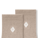 Top part of Adult Crew Socks in Bisque with Kyte Baby logo on a white background