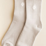 Pair of beige socks with kite pattern on a beige background