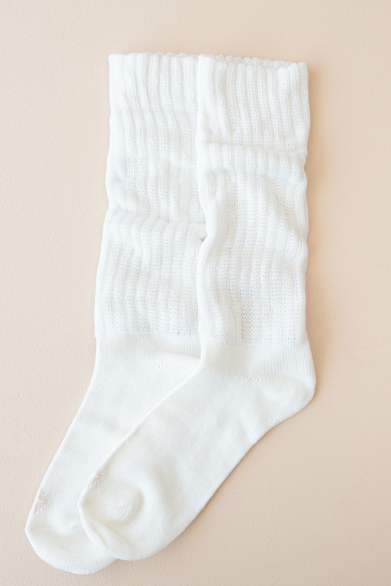 Flat lay of Kyte Scrunch Socks in Cloud with top unfolded