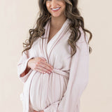 Expectant mother cradling her baby bump wearing the Adult Robe in Blush