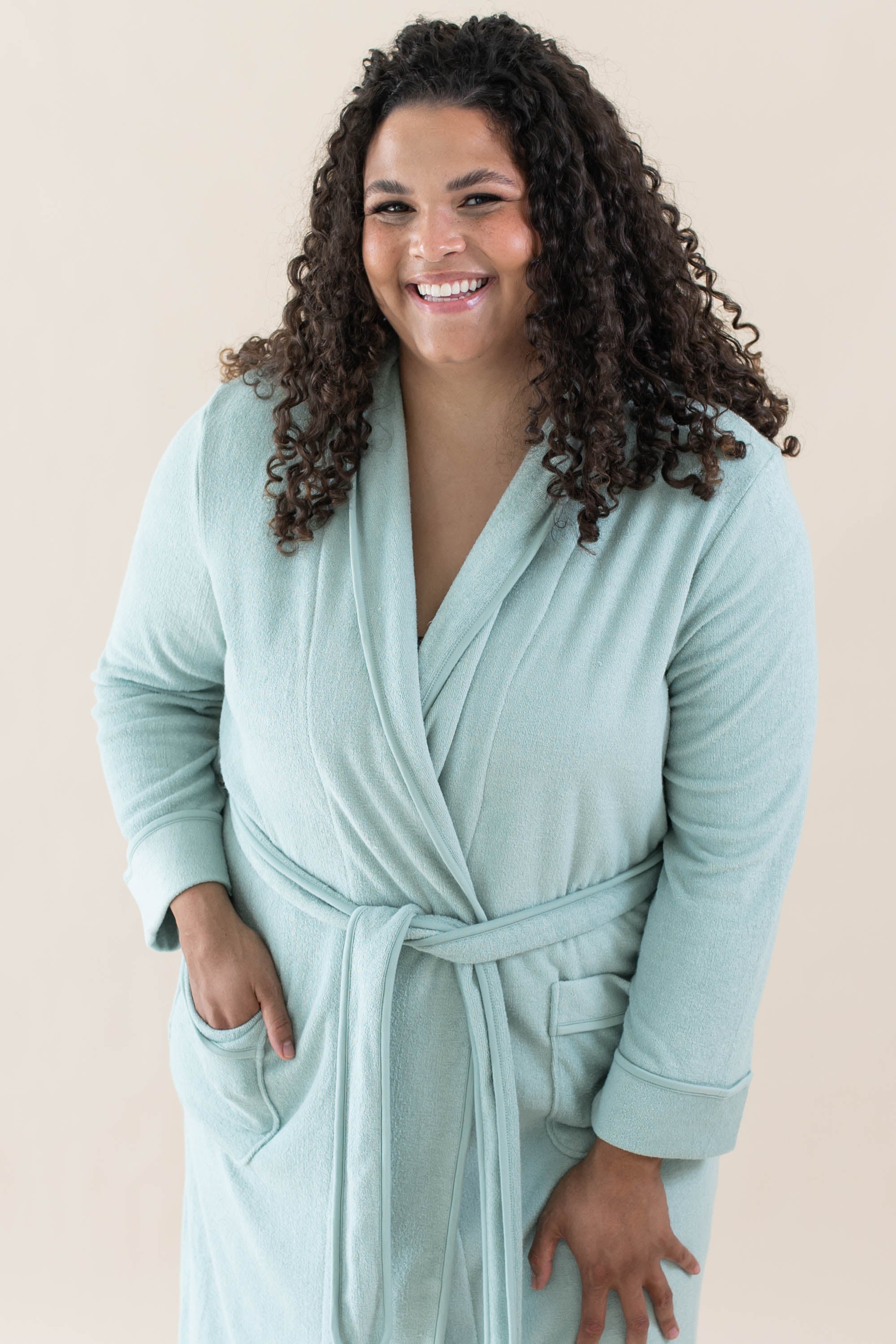 Model wearing the Adult Robe in Sage with one hand in robe pocket and the other hand on her thigh