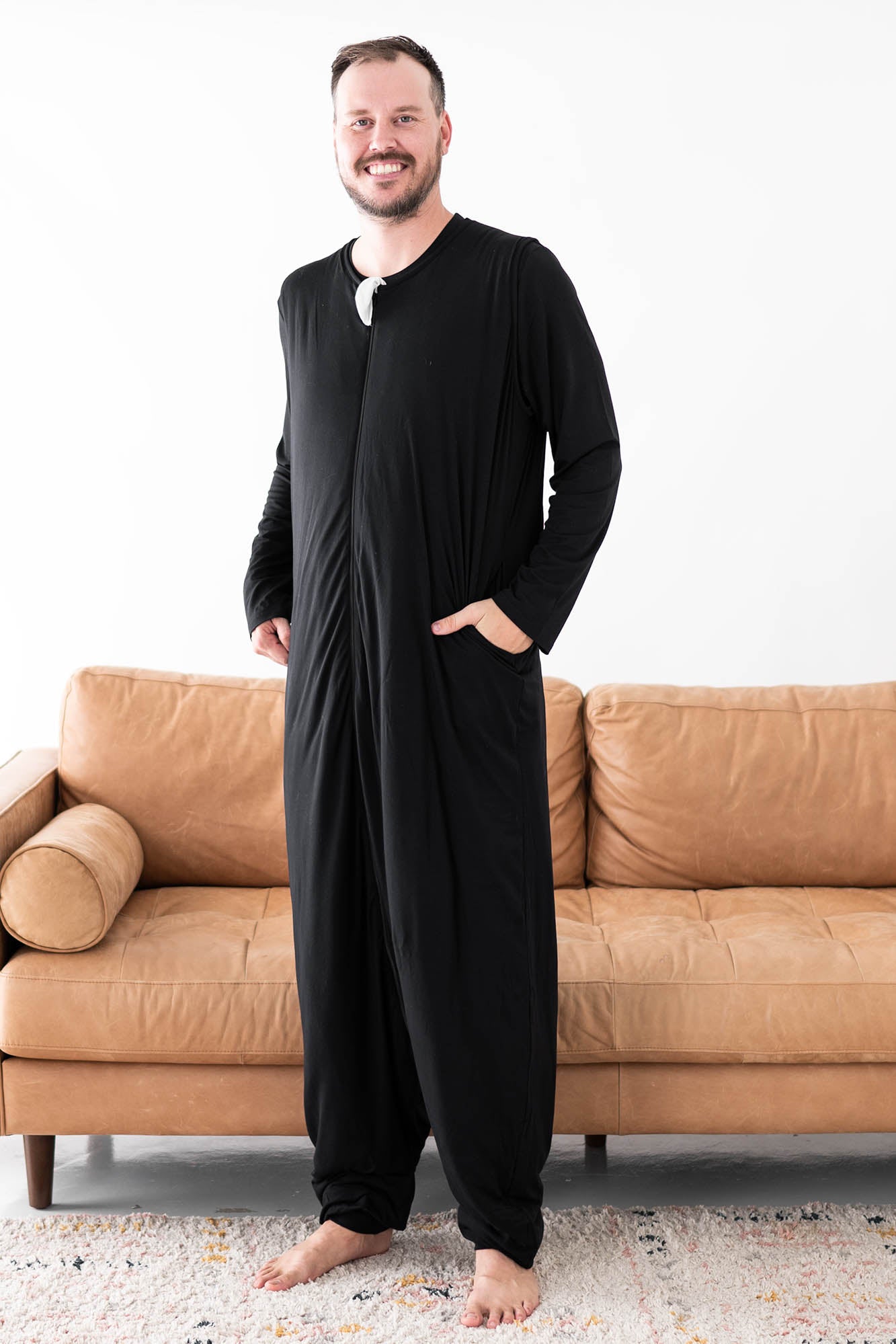 Male model wearing the Adult Sleep Bag Walker in Midnight with one hand in the pocket