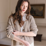 Woman soft smiling pulling up her sleeve wearing a cropped cardigan in almond
::: Model is 5'8" wearing size XS ///
