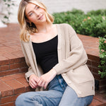 Modal sitting outdoors wearing Chunky Knit Women's Waffle Cardigan in Almond over midnight camisole and blue jeans
::: Model is 5'10" wearing size XS ///