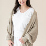 Woman in white outfit modeling Chunky Knit Women's Oversized Cardigan in Almond