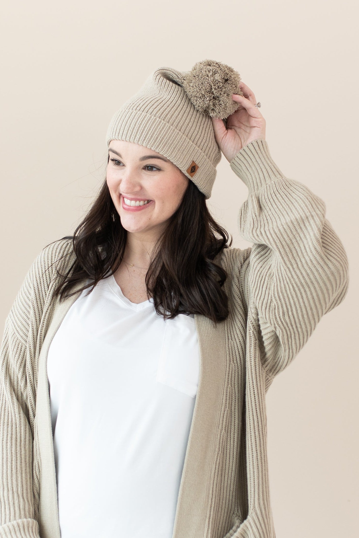 Woman modeling Chunky Knit Women's Oversized Cardigan in Almond and matching Pom Beanie
