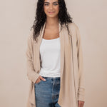 Female wearing the Women's French Terry Wrap Top in Almond with a white shirt and medium wash jeans