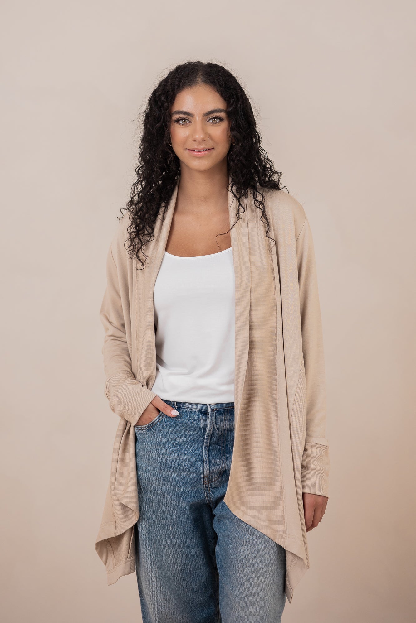 Female wearing the Women's French Terry Wrap Top in Almond with a white shirt and medium wash jeans