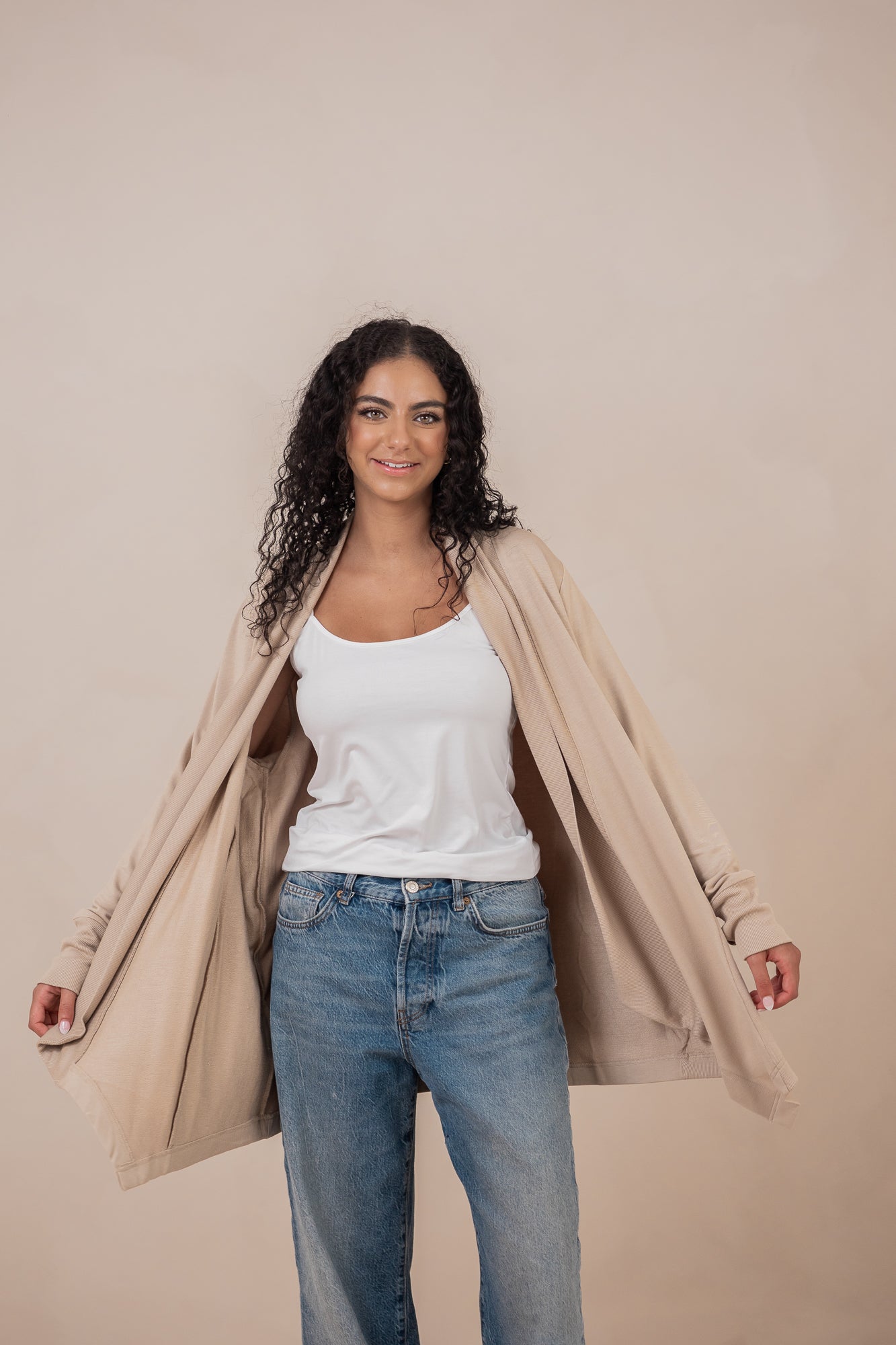 Woman wearing the  Women's French Terry Wrap Top in Almond and opening the sides