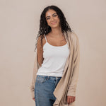 Model with the Women's French Terry Wrap Top in Almond off one shoulder paired with a Cami in Cloud and Jeans