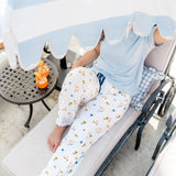 Model sitting on a pool lounge chair under an umbrella wearing the Women's lounge pant in Amalfi Coast