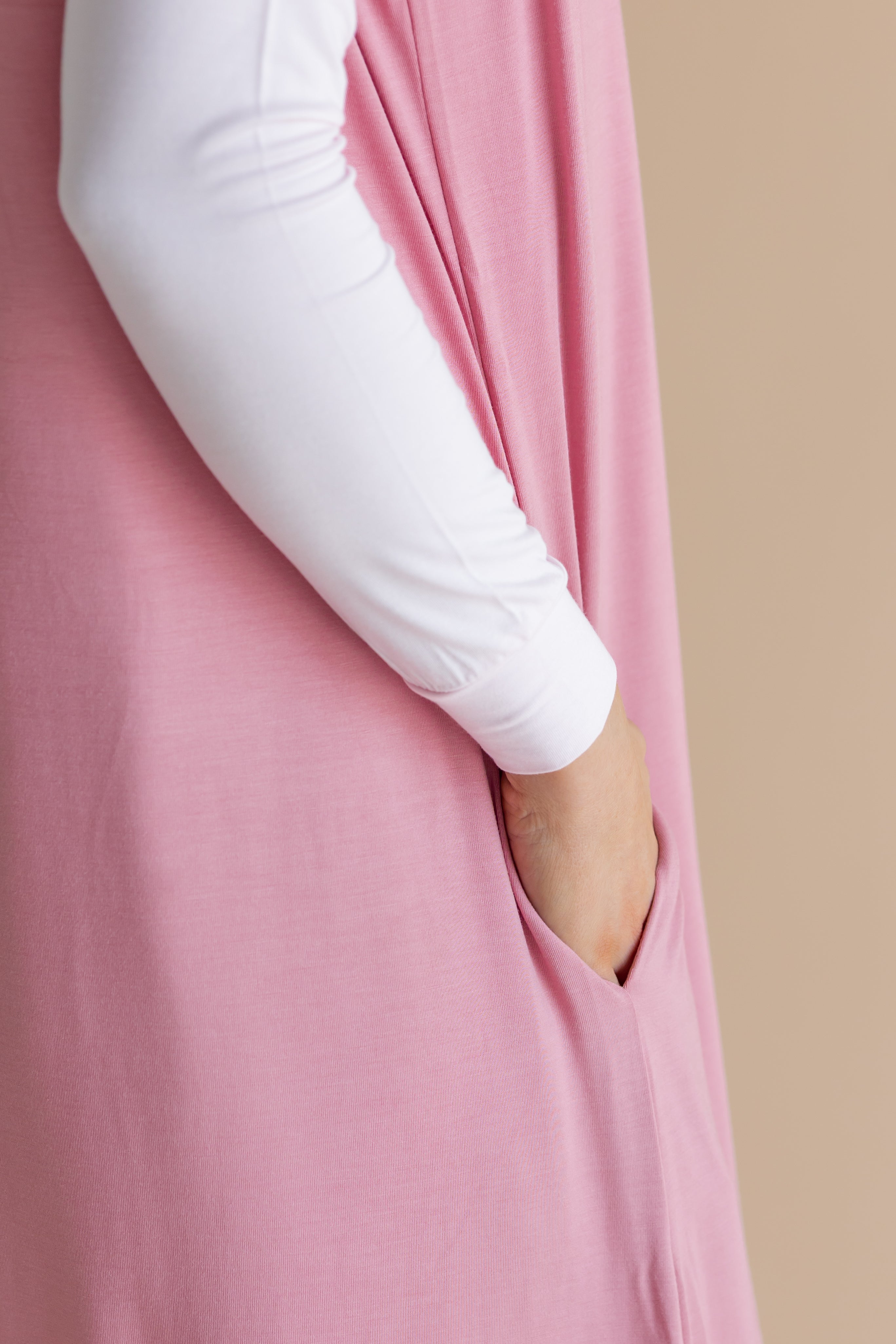 Close up of the model showcasing the pocket on the  Adult Sleep Bag Walker in Apple Blossom