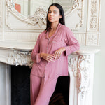 Woman leaning on a fireplace with her arm propped up wearing a long sleeve pajama set in apple blossom.
::: Model is 5'10.5" wearing size S ///
---PJ 4