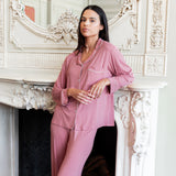 Woman leaning on a fireplace with her arm propped up wearing a long sleeve pajama set in apple blossom.
::: Model is 5'10.5" wearing size S ///
---PJ 4