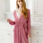 Woman wearing a pink robe in a bathroom setting