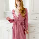 Woman wearing a pink robe in a bathroom setting