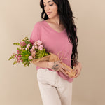 Woman modeling Women’s Relaxed Fit V-Neck in Apple Blossom holding bouquet 