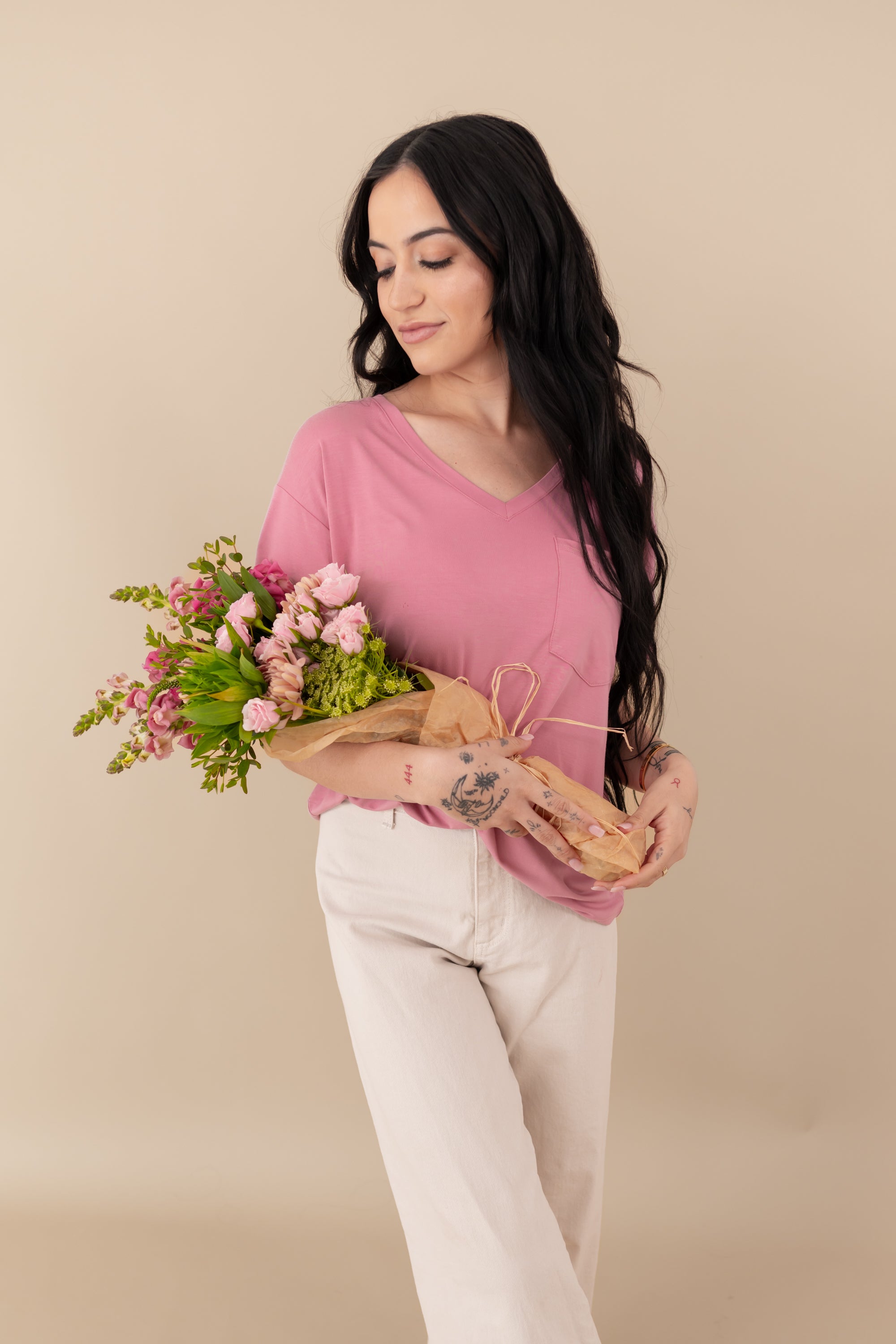 Woman modeling Women’s Relaxed Fit V-Neck in Apple Blossom holding bouquet 
