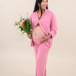 Model wearing Women's Long Sleeve Pajama Set in Apple Blossom with Cloud Trim with some buttons undone to show baby bump