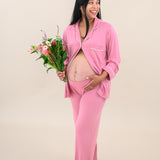 Model wearing Women's Long Sleeve Pajama Set in Apple Blossom with Cloud Trim with some buttons undone to show baby bump