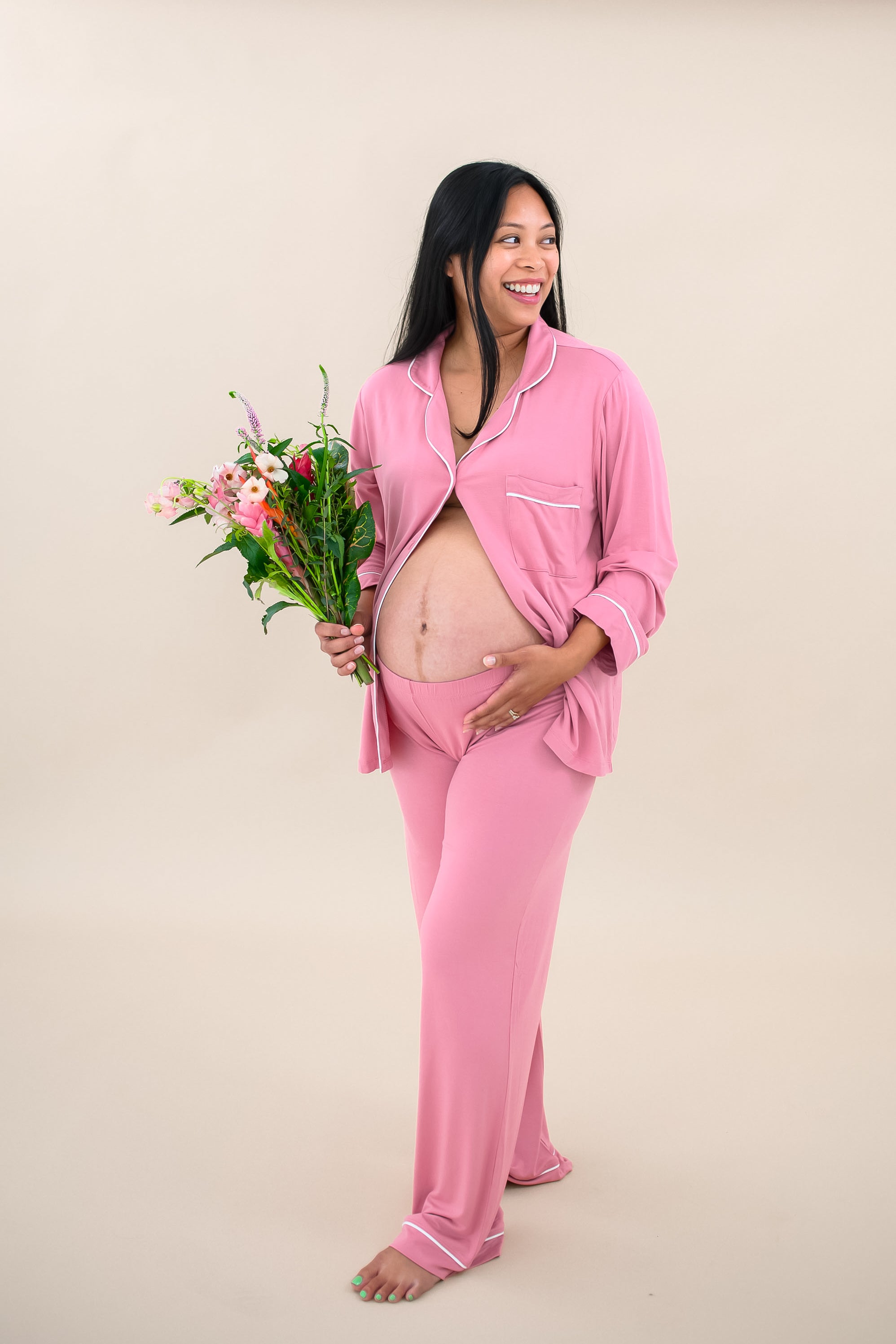 Model wearing Women's Long Sleeve Pajama Set in Apple Blossom with Cloud Trim with some buttons undone to show baby bump