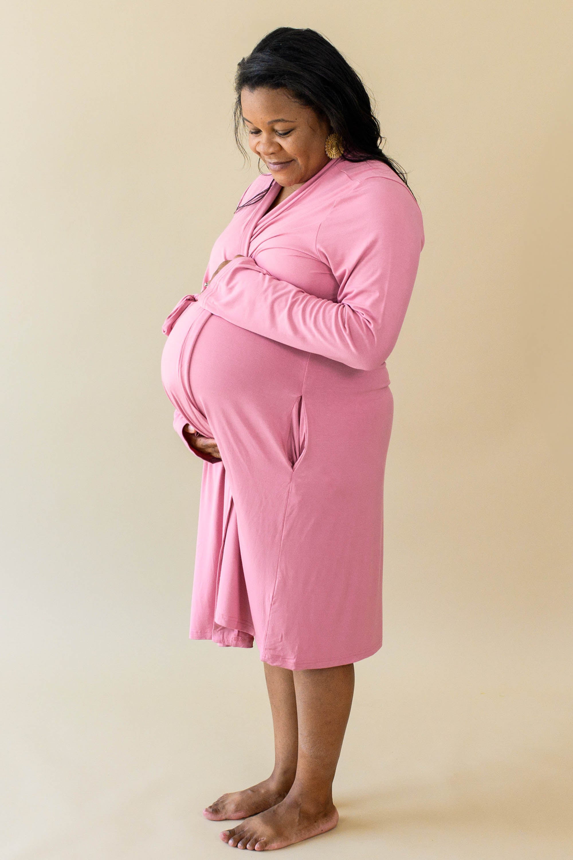 Expectant mother cradling her baby bump wearing the Women’s Lounge Robe in Apple Blossom