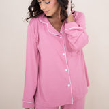 Close up of the top from Kyte Women's Long Sleeve Pajama Set in Apple  Blossom with Cloud Trim while model looks downwards