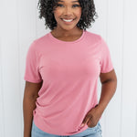 Smiling woman modeling the Kyte Crew Neck Tee in Apple Blossom paired with light blue jeans