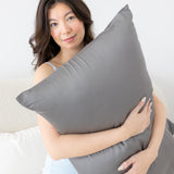 Female holding a pillow with the Bamboo Sateen Pillowcase in Ash on it