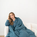 Model wrapped in a Kyte Quilt Blanket in Atlantic and matching Long Sleeve Pajama Set
