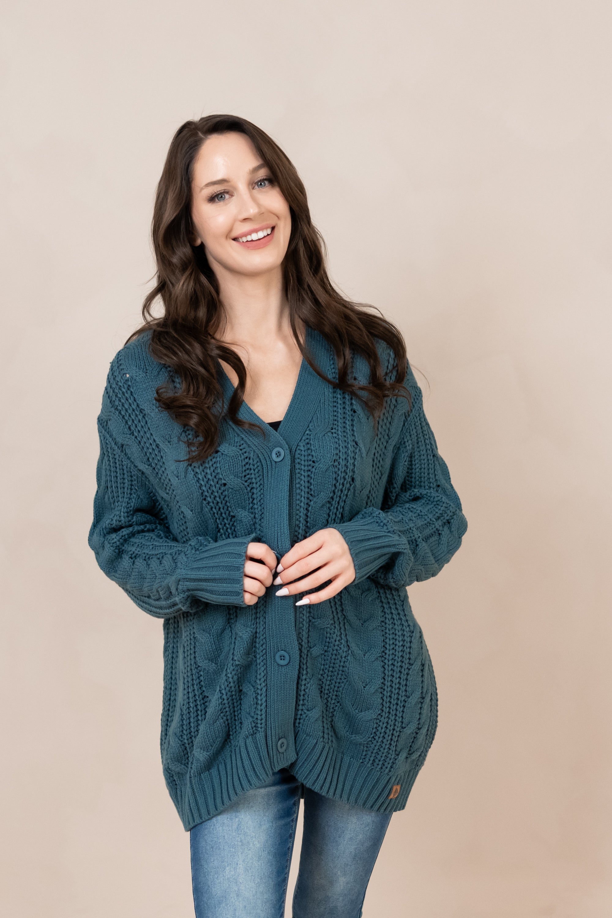 Smiling model wearing the Chunky Cable Knit Cardigan in Atlantic while buttoned up 