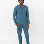 Male model standing wearing the Men's Ribbed Henley Set in Atlantic with one hand in the pants pocket in front of a white back drop