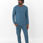 Male model standing looking off to the side with one hand in the pants pocket of the Men's Ribbed Henley Set in Atlantic in front of a white background