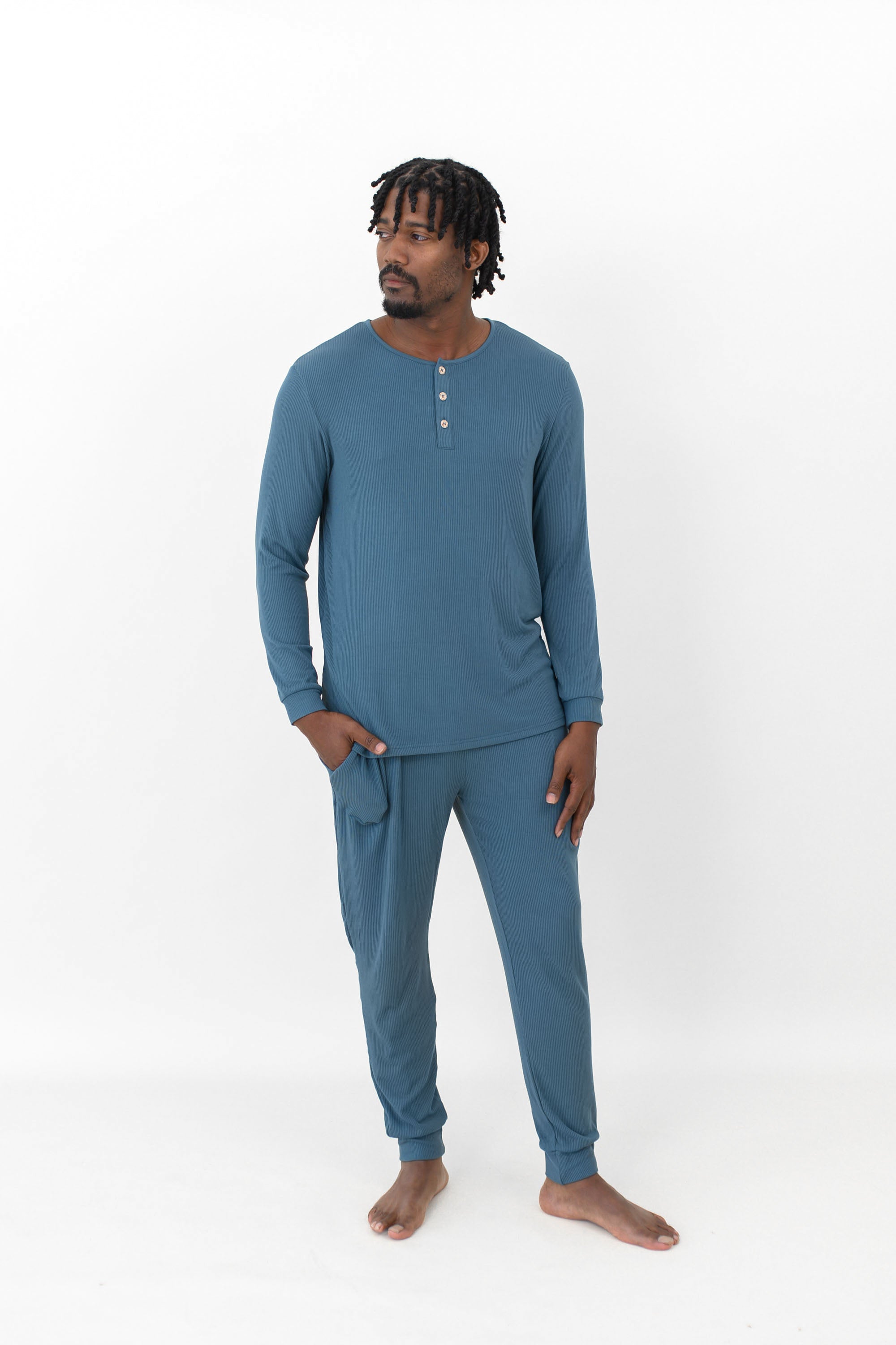 Male model standing looking off to the side with one hand in the pants pocket of the Men's Ribbed Henley Set in Atlantic in front of a white background