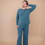 Male model with head on shoulder modeling the Men's Lounge Pants in Atlantic and matching Long Sleeve Henley Tee