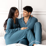 Couple wearing matching bamboo pajamas in a teal color