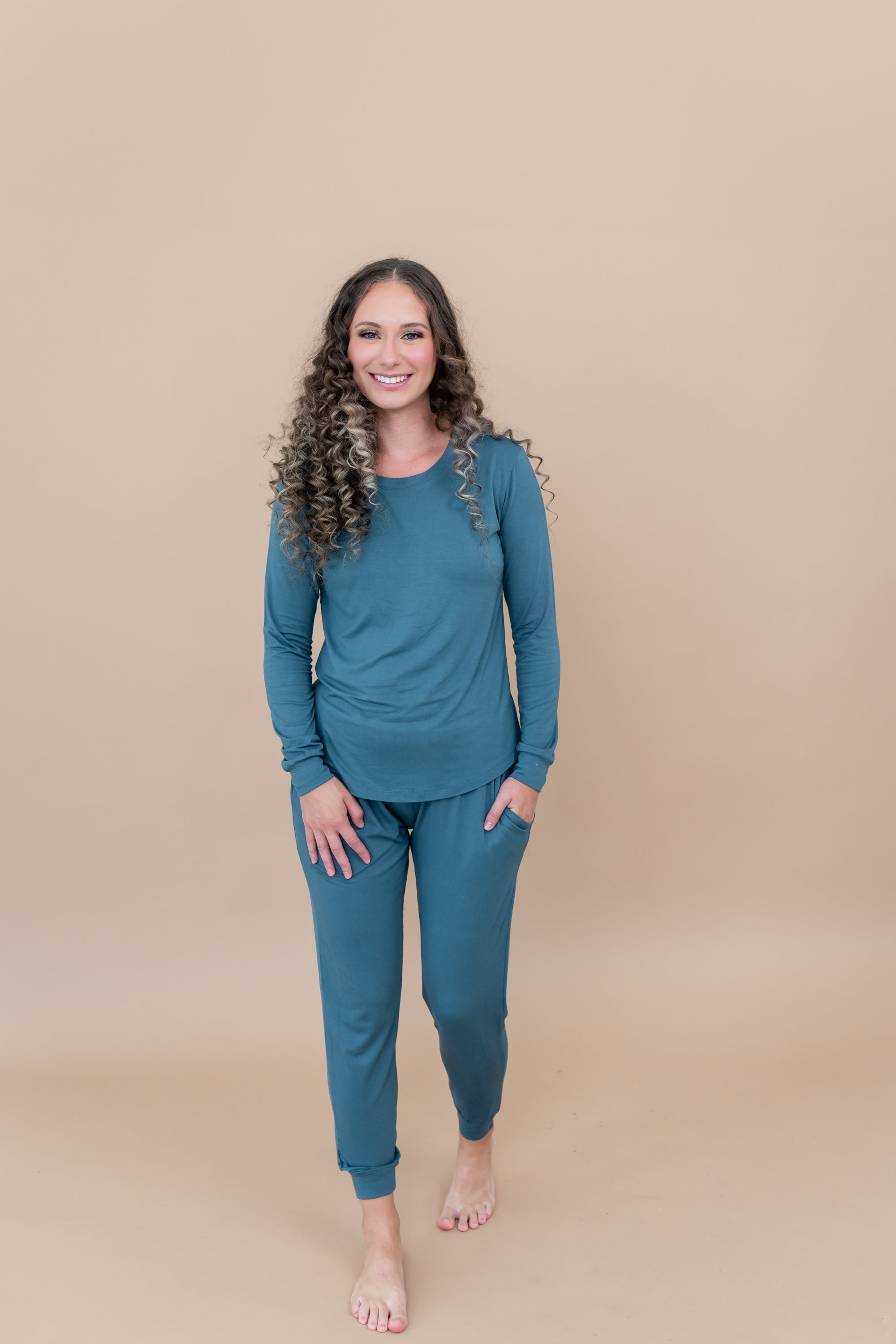 Model stepping forward with hand in pocket while wearing the Women's Jogger Set in Atlantic