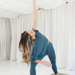 Female model doing yoga wearing the Bamboo Flex Women’s Leggings in Atlantic and matching short sleeve tee