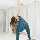 Female model doing yoga wearing the Bamboo Flex Women’s Leggings in Atlantic and matching short sleeve tee