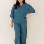 Model looking to the side with hand on her hip while wearing the Bamboo Women's Wide Leg Pant Set in Atlantic