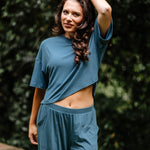 Model standing outside while wearing the Women's Short Sleeve Tee in Atlantic and matching wide leg pants