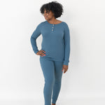 Woman looking to the side with one hand on her hip while modeling the Women’s Ribbed Henley Set in Atlantic